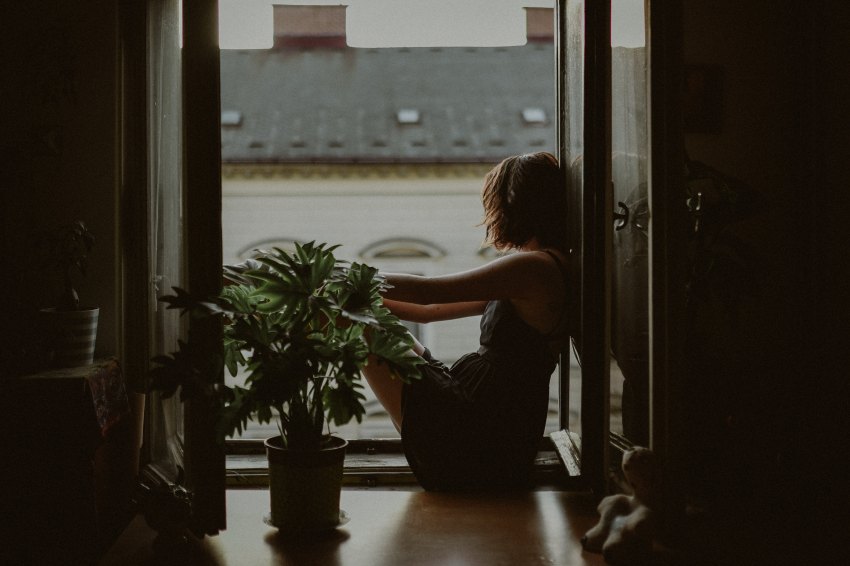 woman sitting looking outside of window