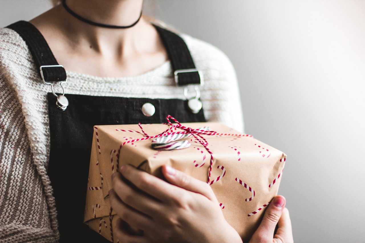 woman in overalls holding a present