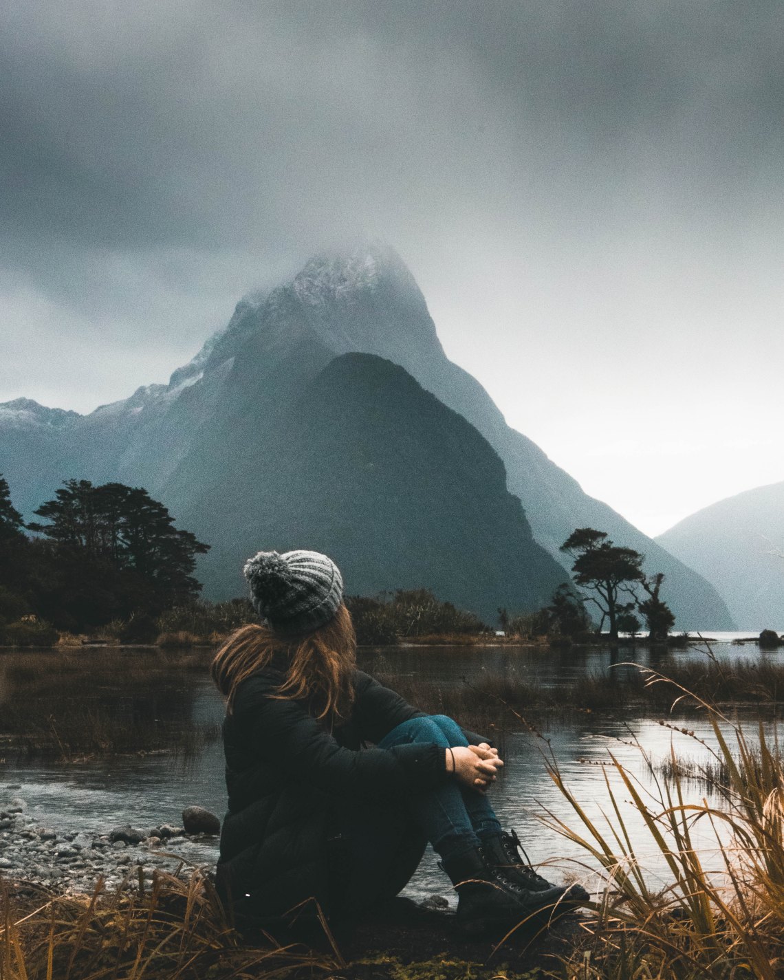 girl sitting in front of a mountain