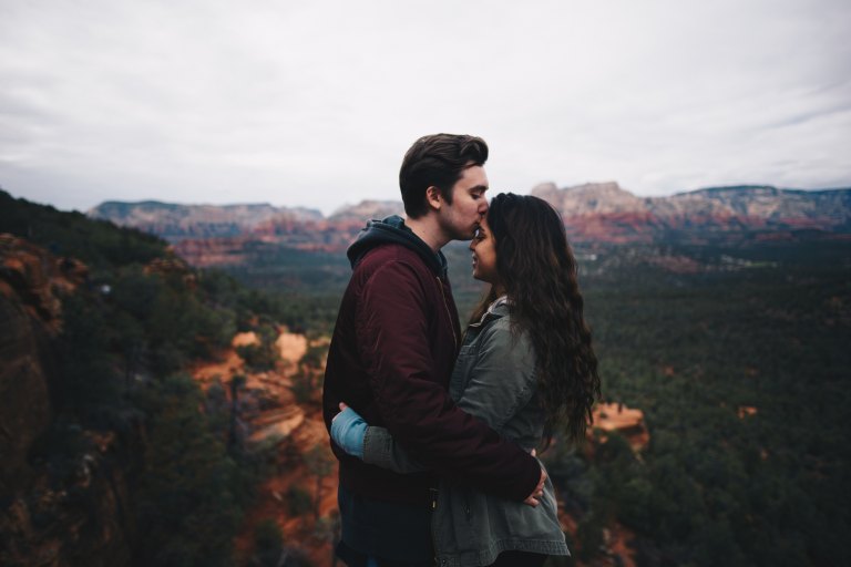 man kisses woman's forehead