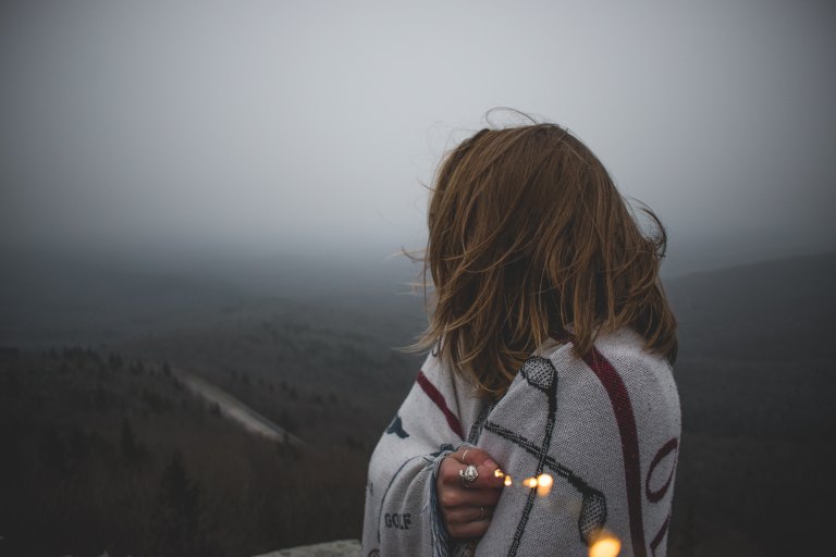 woman standing on hill with light