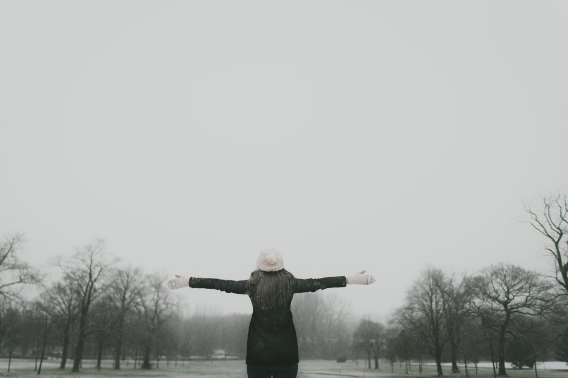 woman in winter with arm's extended