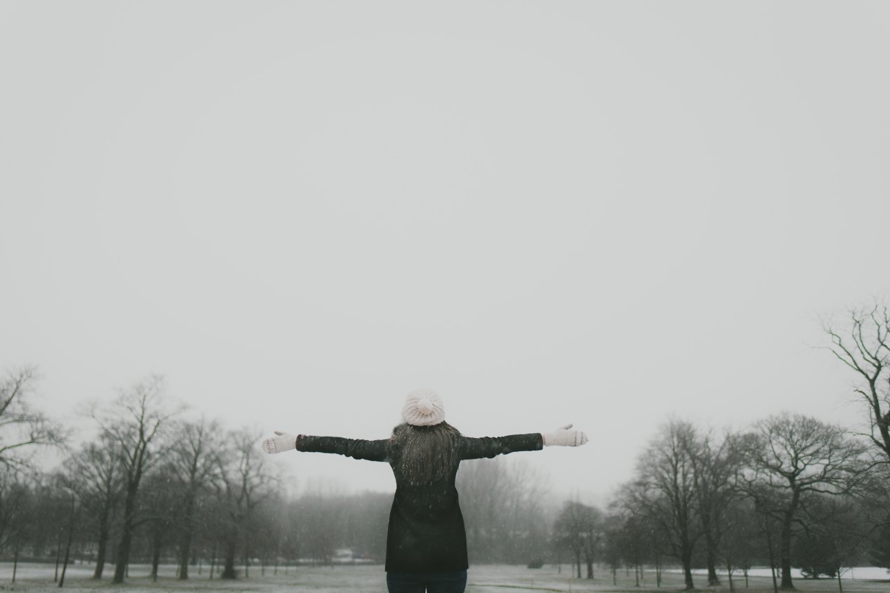 woman in winter with arm's extended