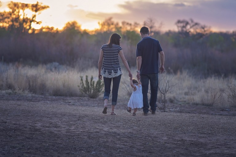 mom dad and child walking