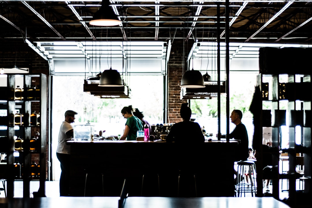 The interior of a coffee house with baristas and several customers