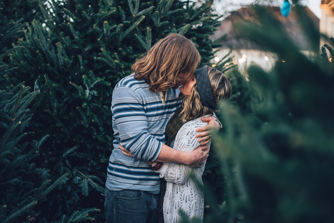 Couple kissing among pine trees in Nashville