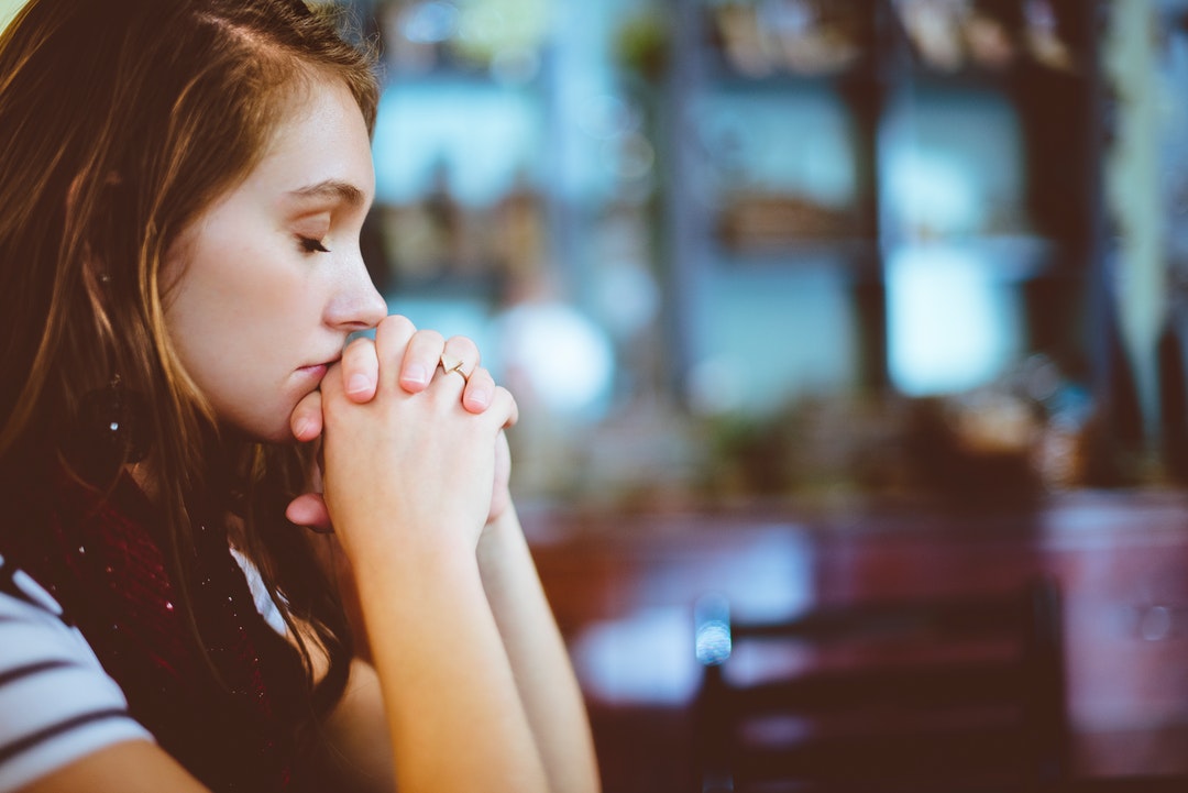 A woman sitting with her chin on her hands