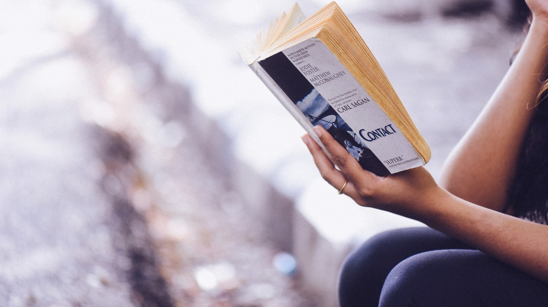 A woman wearing a ring reading a book in Besant Nagar