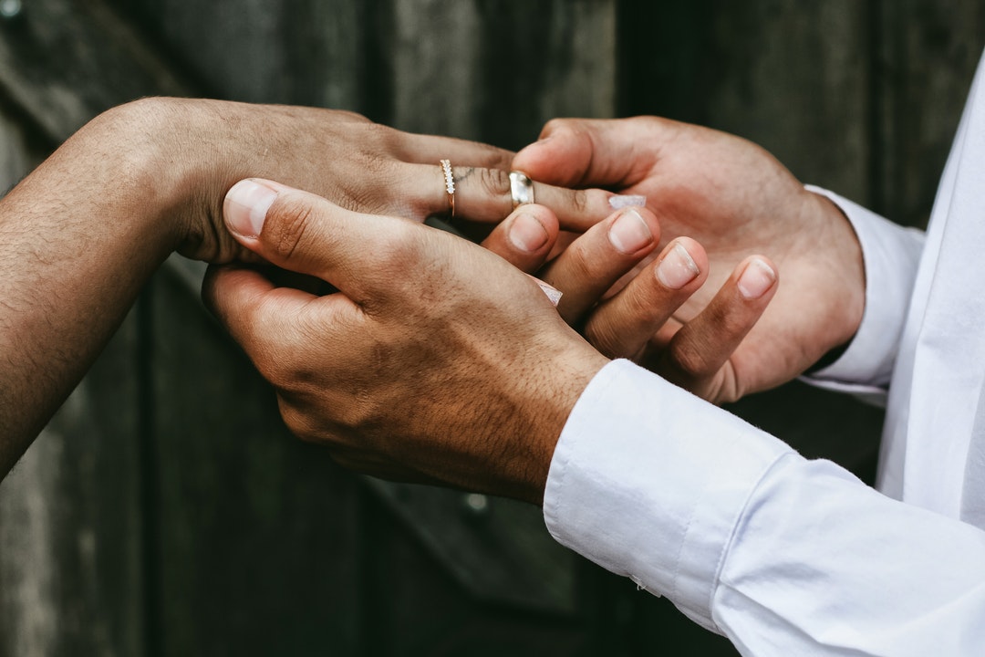 Groom slips the ring on the finger of his bride on their wedding day