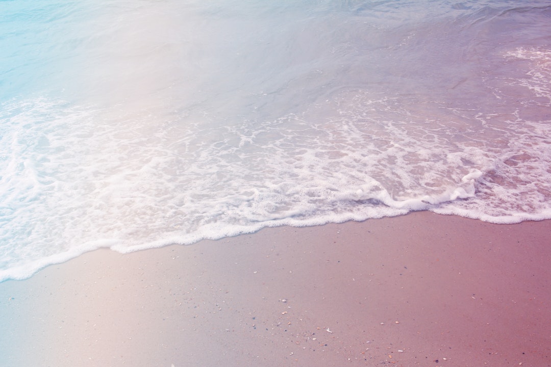 Drone view of the ocean wave washing on the sand beach