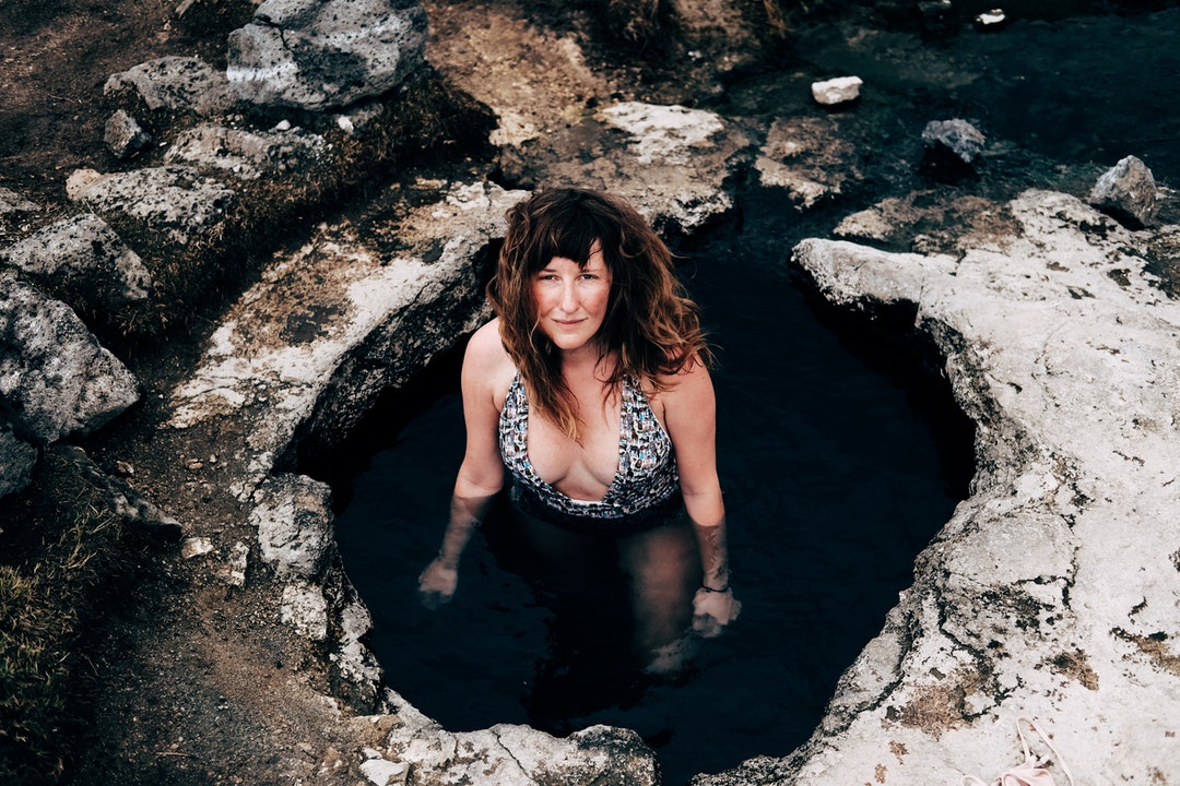 Woman in a swimsuit standing in a natural hot spring