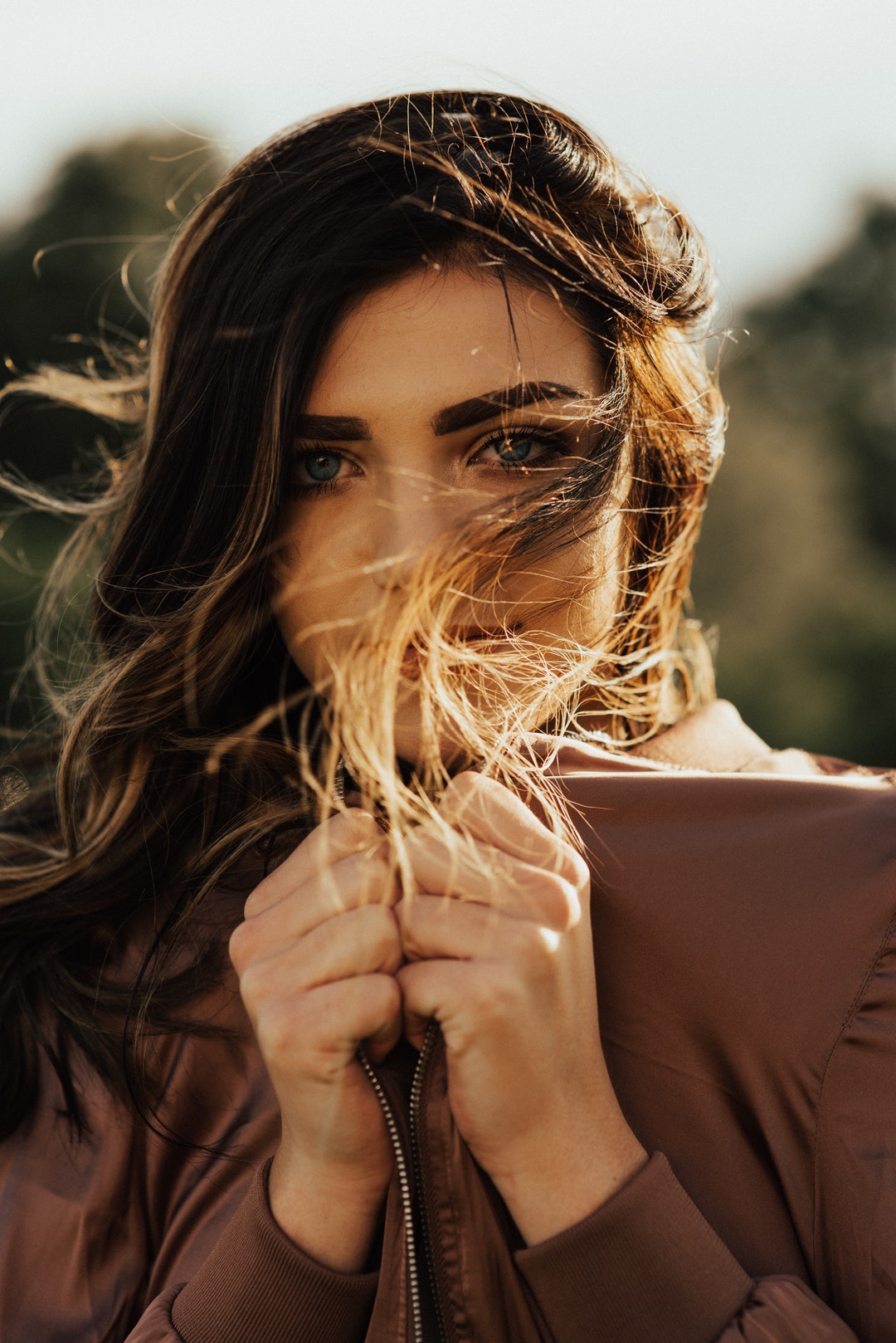 A woman in a brown jacket with her hair blowing in the wind in Salt Lake City