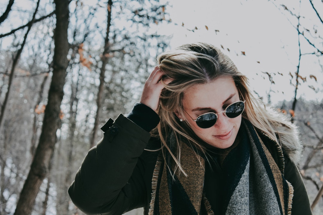 Woman pushes her hair while taking a winter walk outside