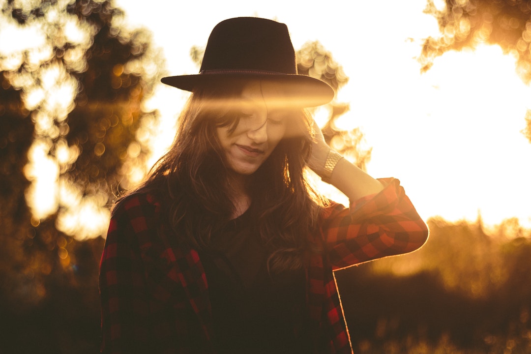 A woman wearing a red and black plaid jacket during golden hour in Cianorte