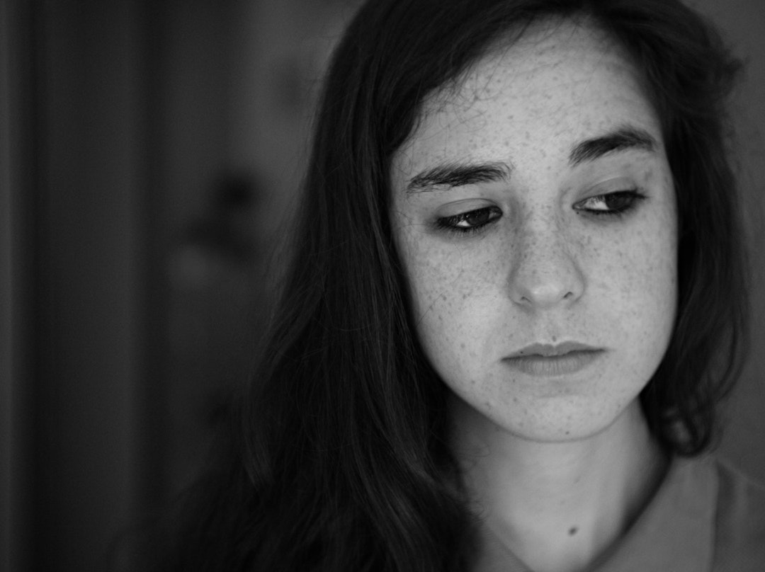 Black and white close up shot of young woman with freckles wearing collar shirt