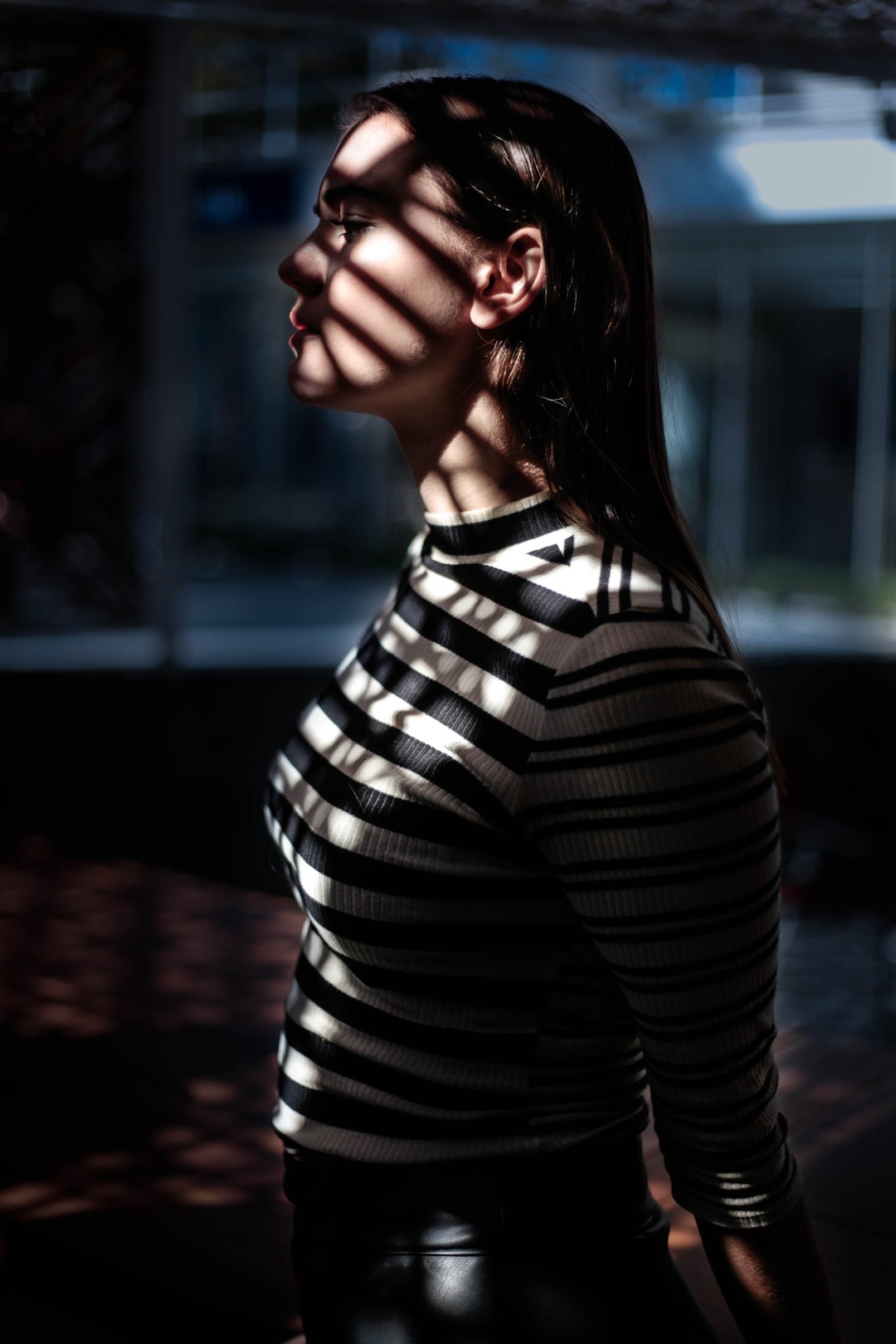 A sad woman in a striped shirt.