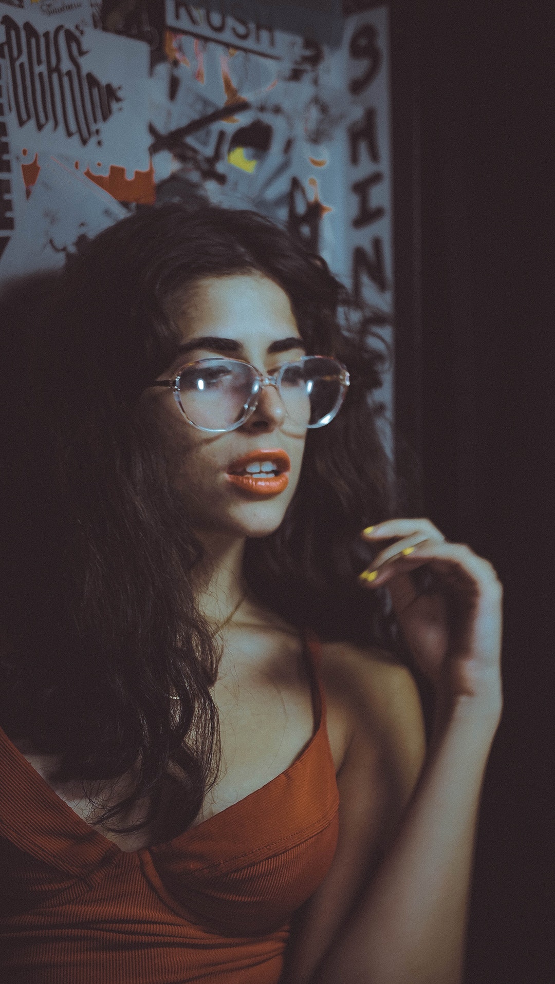 woman in brown spaghetti strap top beside white wall