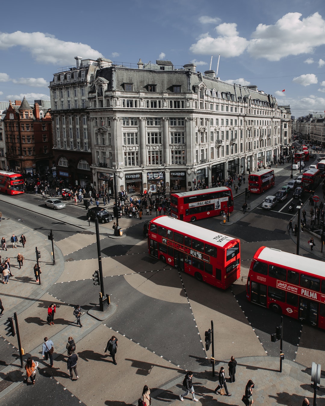 people walking on street near red double-deck buses