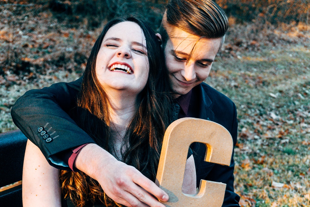 boy hugging girl while holding C letter cutout