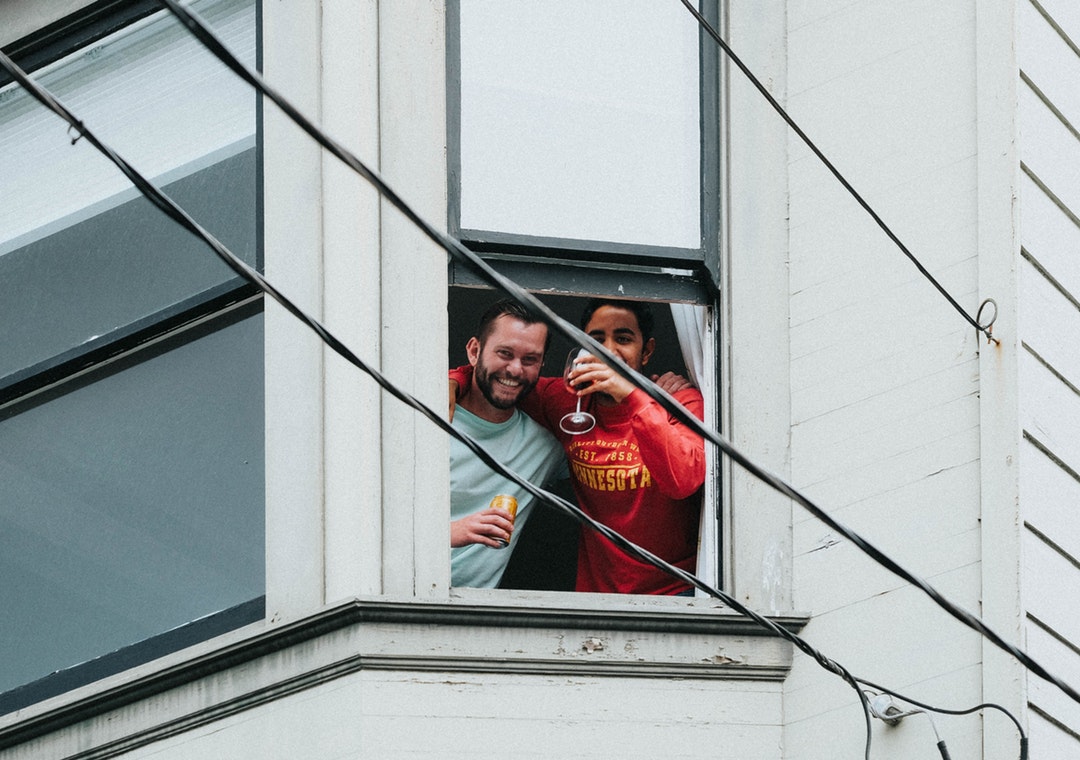 man and woman on window drinking together