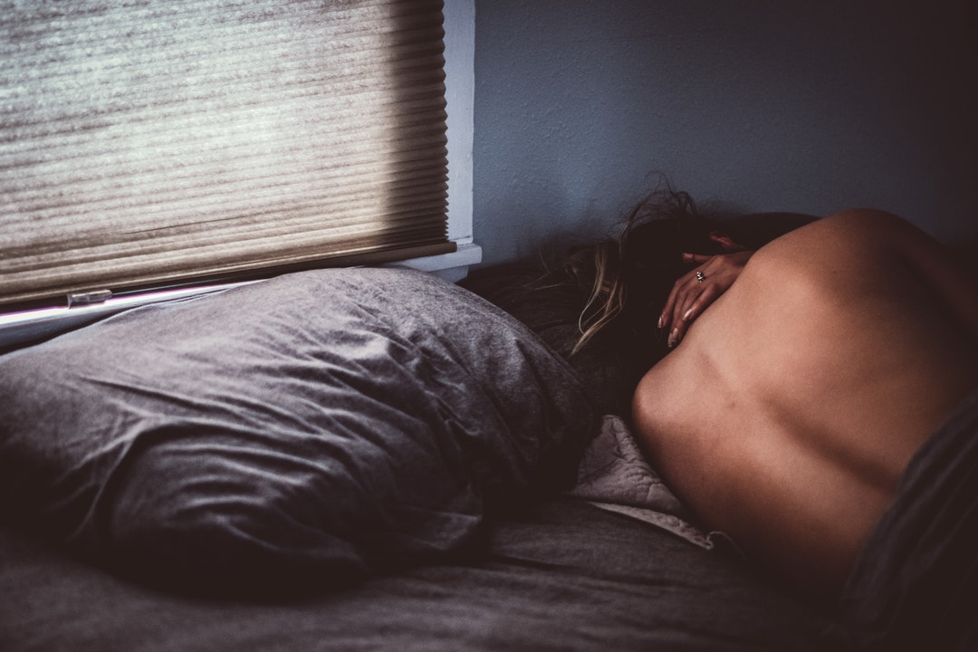 topless woman lying on bed