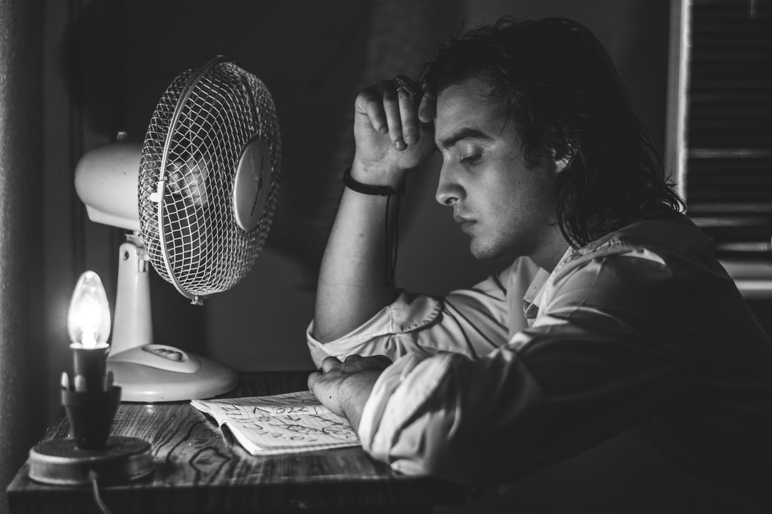 man in dress shirt sitting in front of table