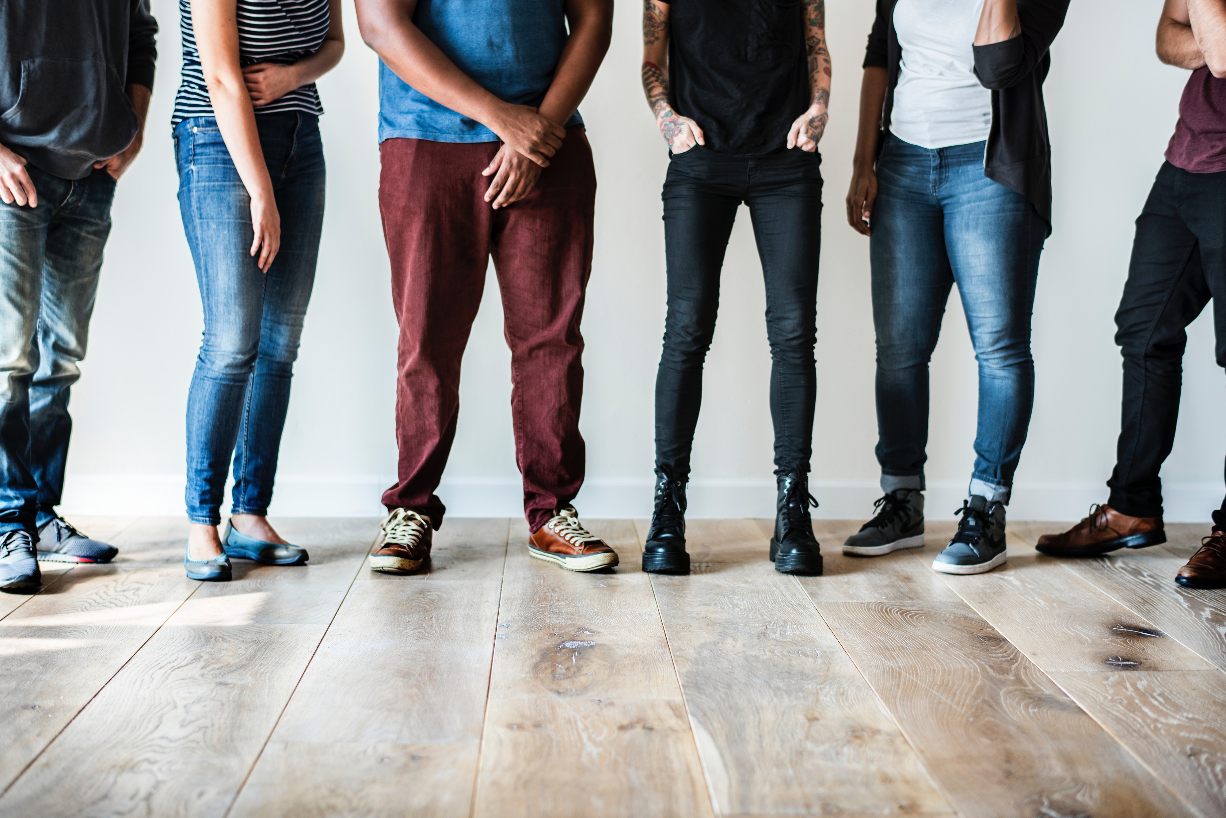 group of people standing in front of white wall