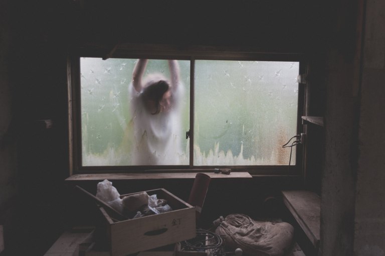 woman standing outside window