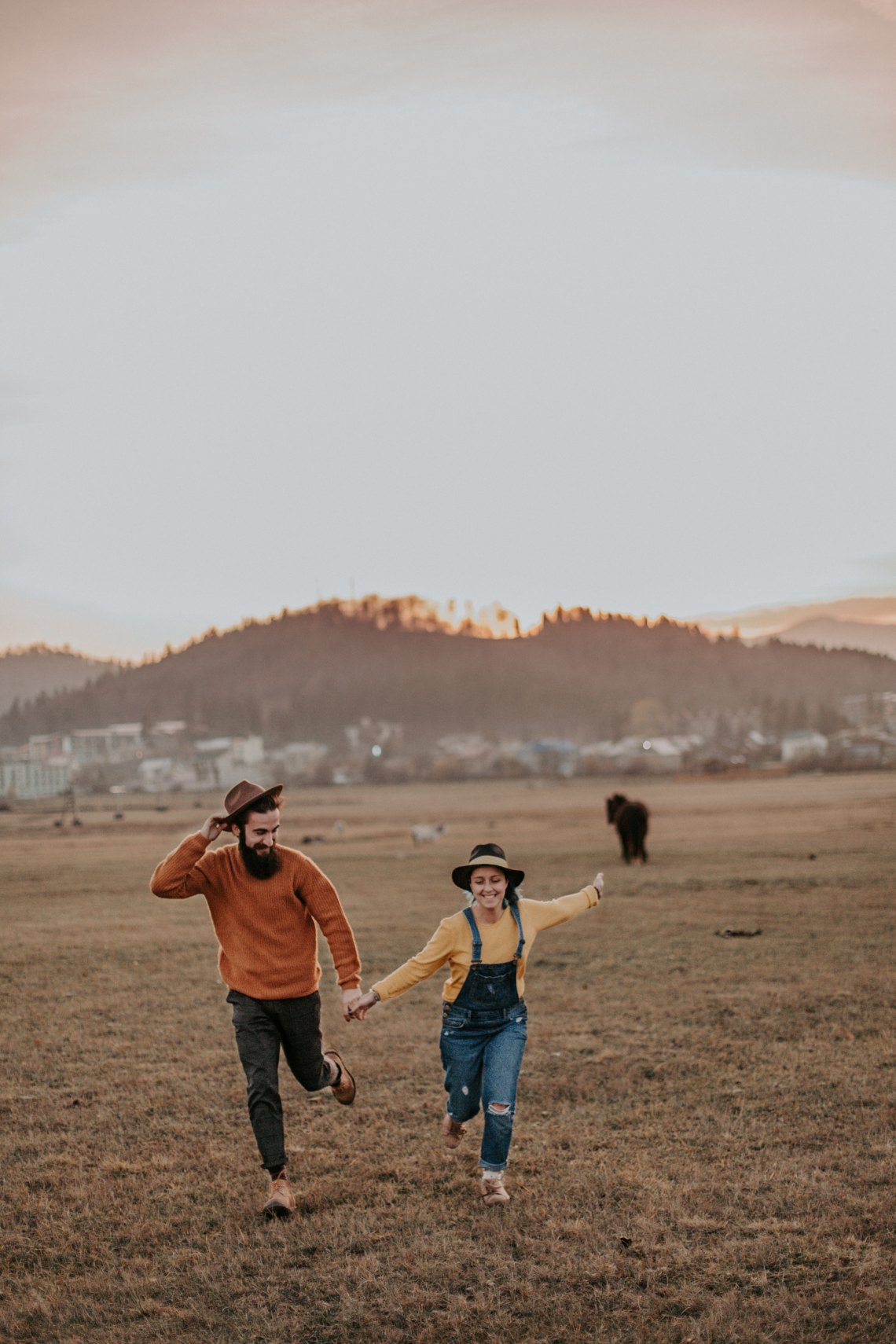 couple running happily through a field