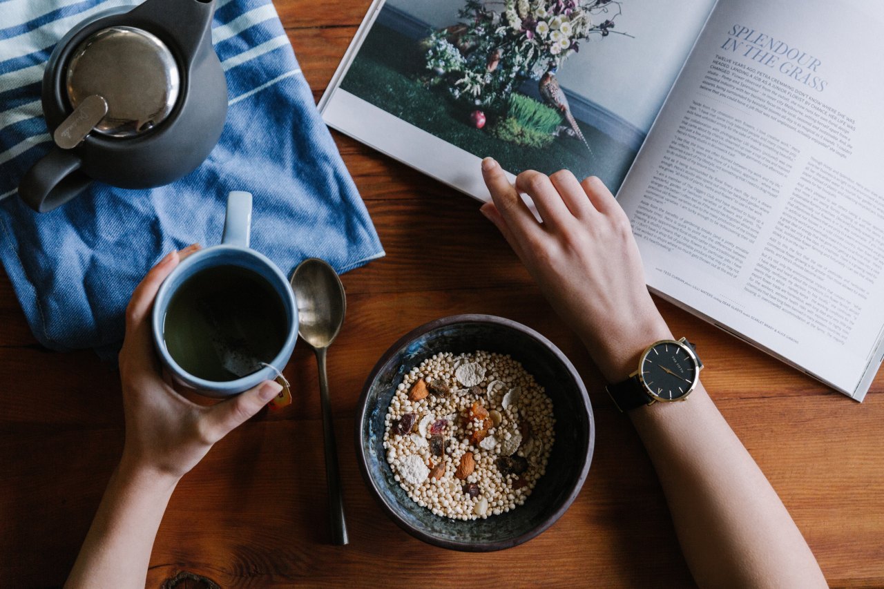 someone eating very healthy food while ready a very trendy magazine