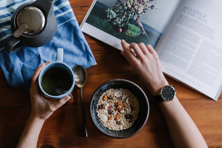 someone eating very healthy food while ready a very trendy magazine