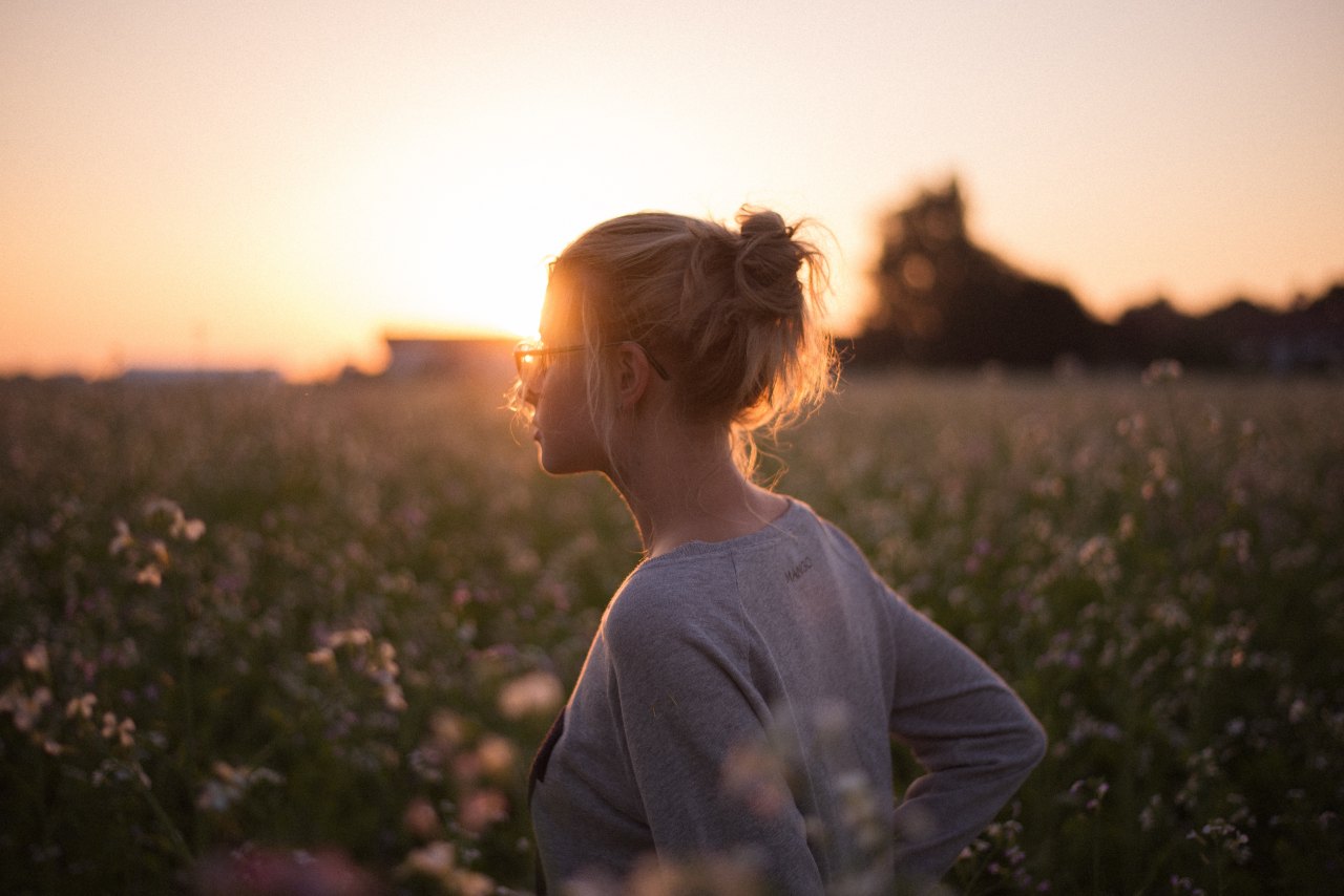 girl in a field with a sunburst