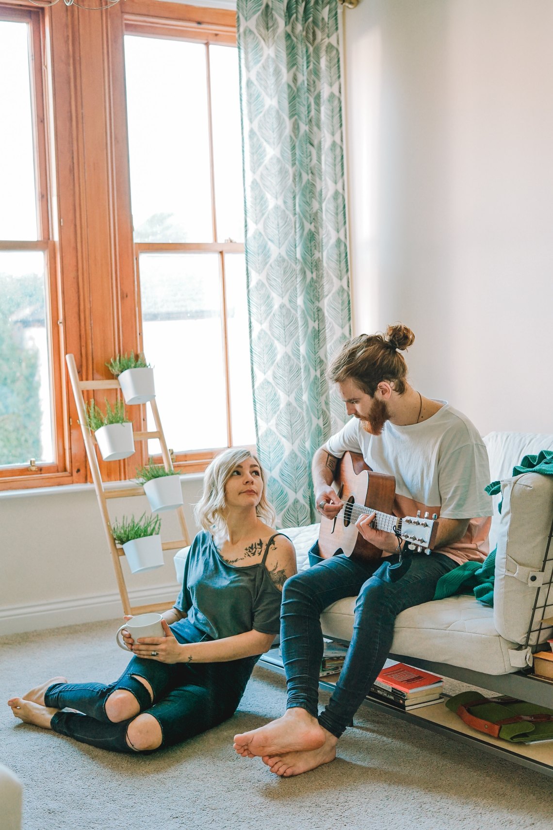 woman watching man play guitar