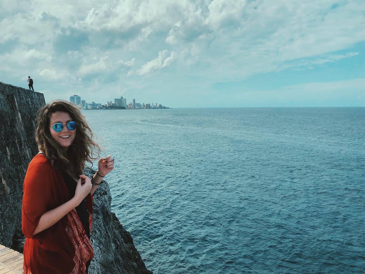 girl standing by the ocean smiling