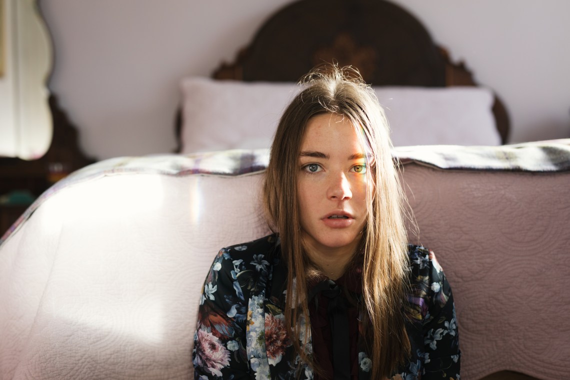 Distressed Single Girl Sits At The Foot Of Her Bed