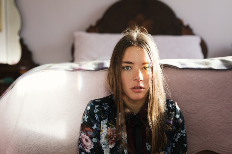 Distressed Single Girl Sits At The Foot Of Her Bed