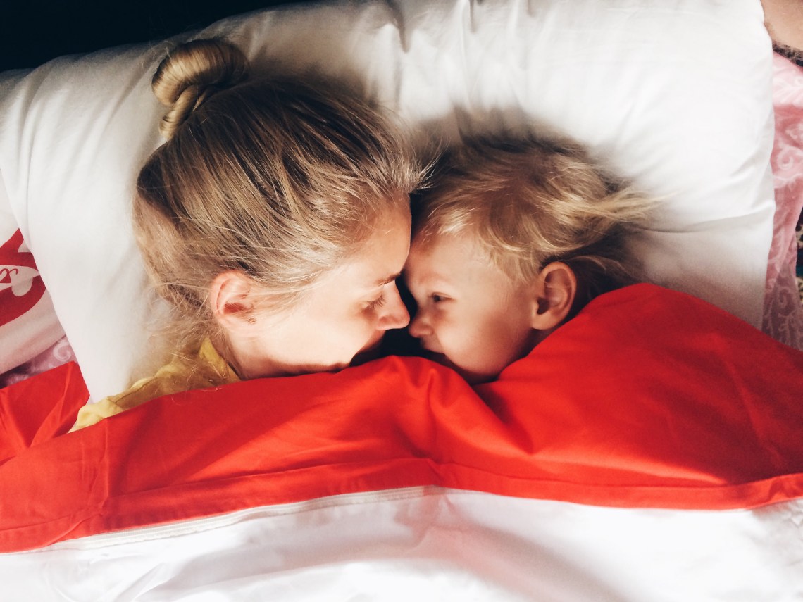 mother and child in bed laughing together 