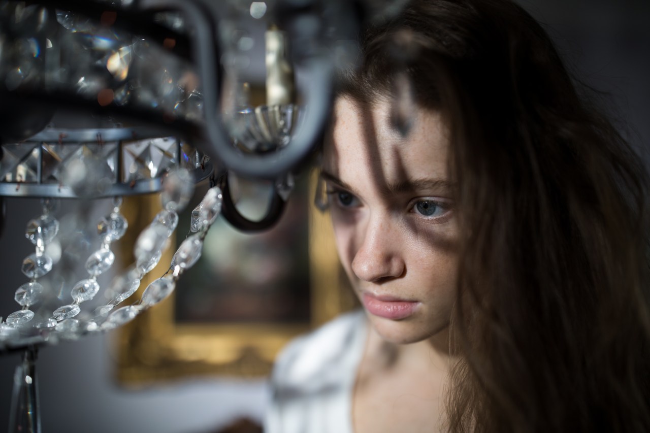 woman looking sad by chandelier