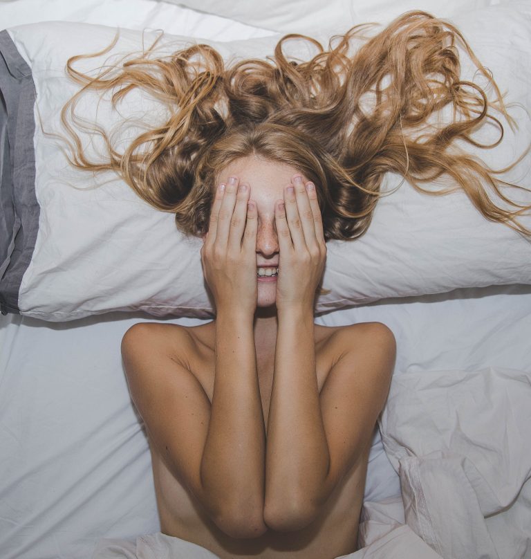 woman laying looking happy with eyes covered