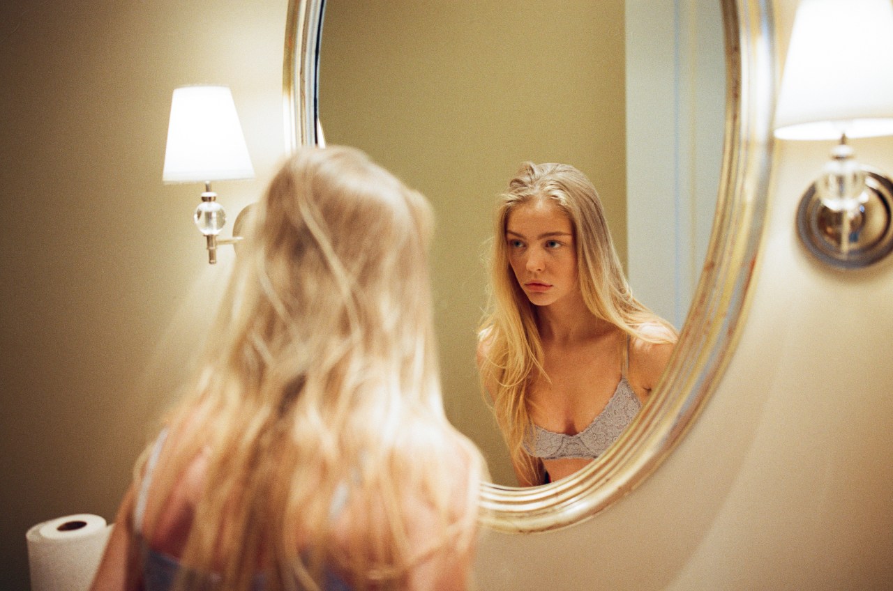 woman staring in mirror