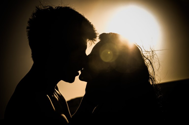 A couple kissing in the sunlight