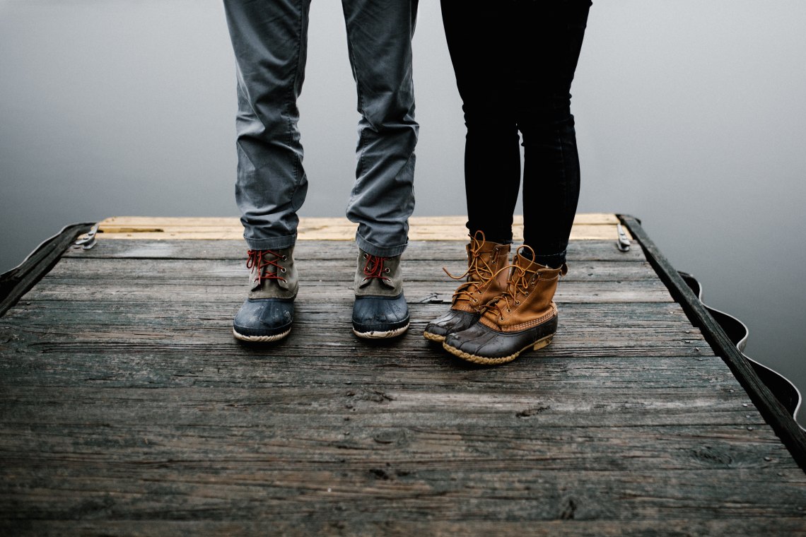 Couple's feet standing on dock