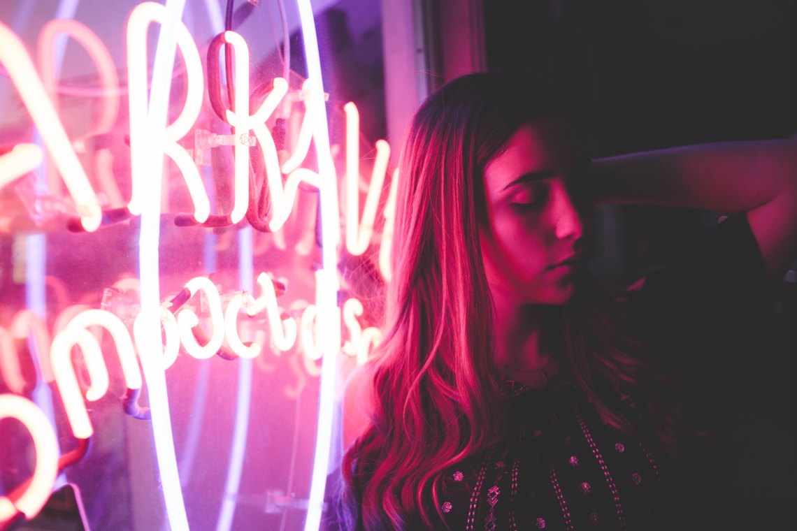 woman next to neon