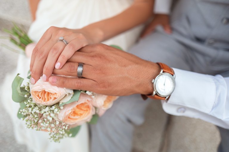 man holds his bride's hands during his wedding