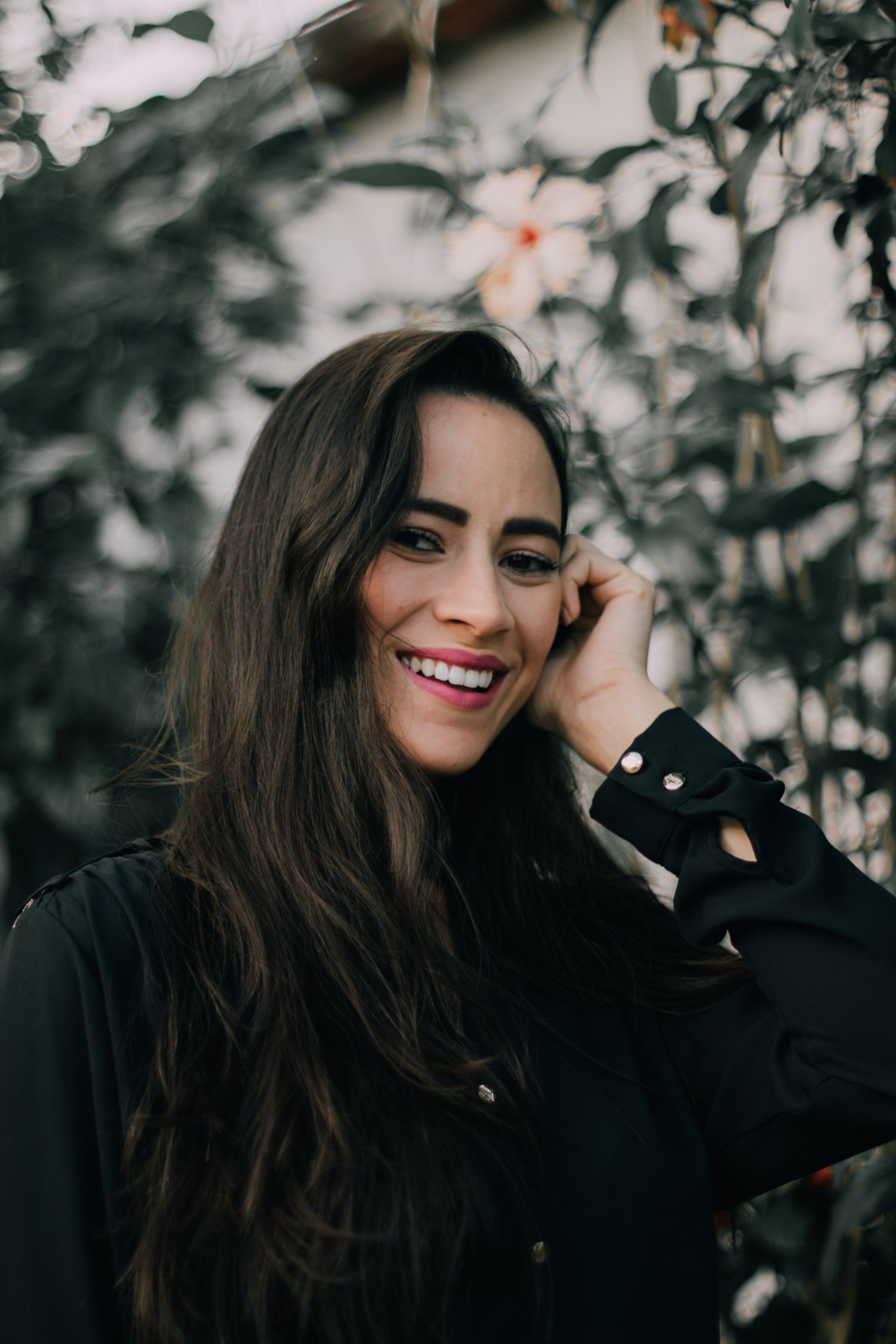 girl laughing next to greenery 