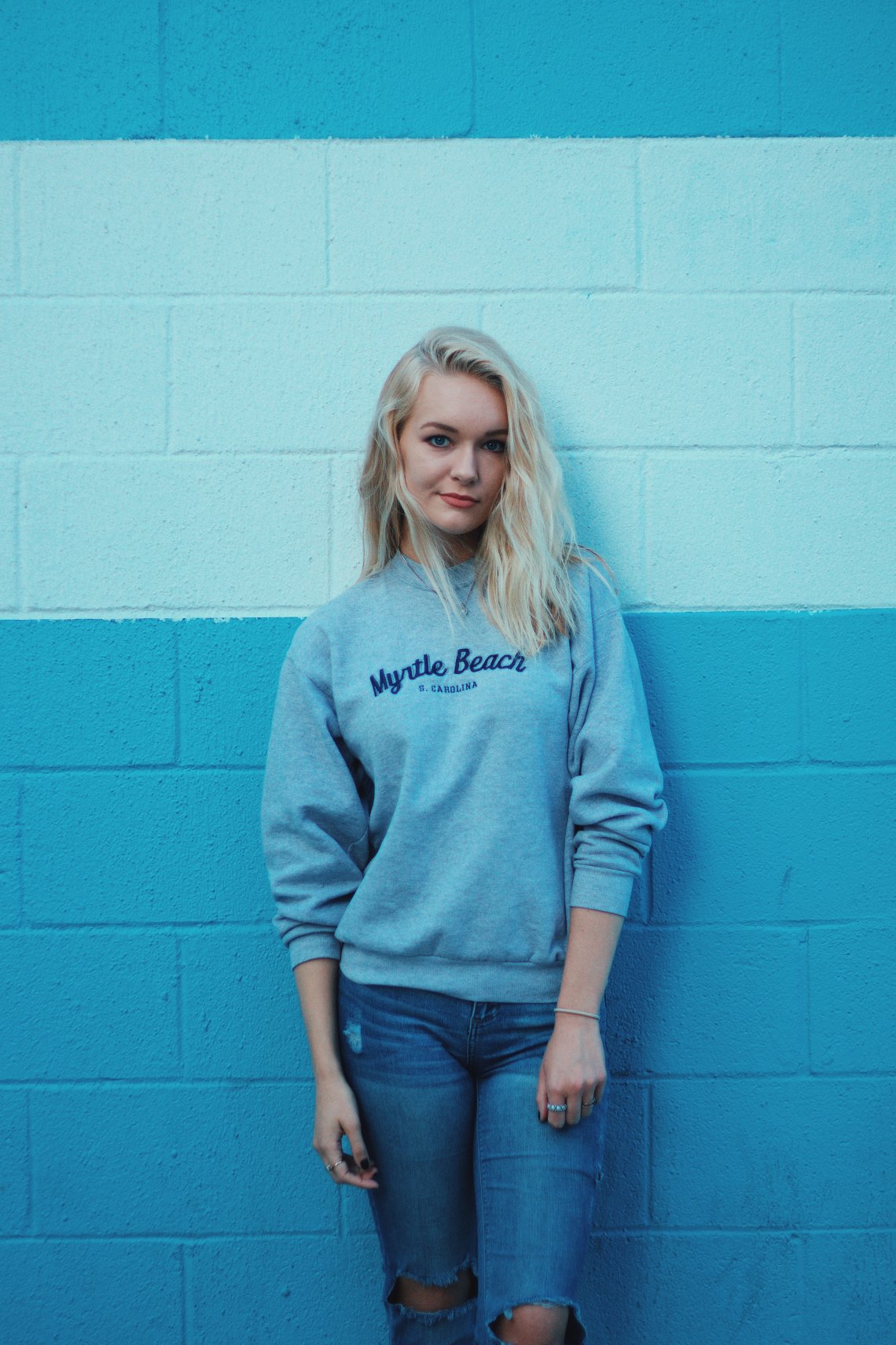 girl against a blue striped wall