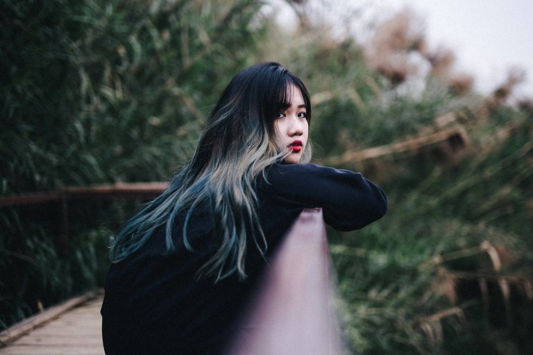 girl leaning on a fence