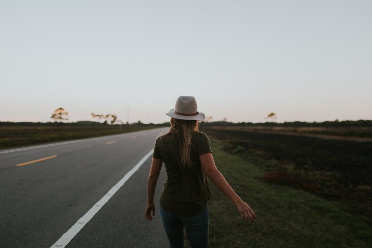 woman walking alongside road