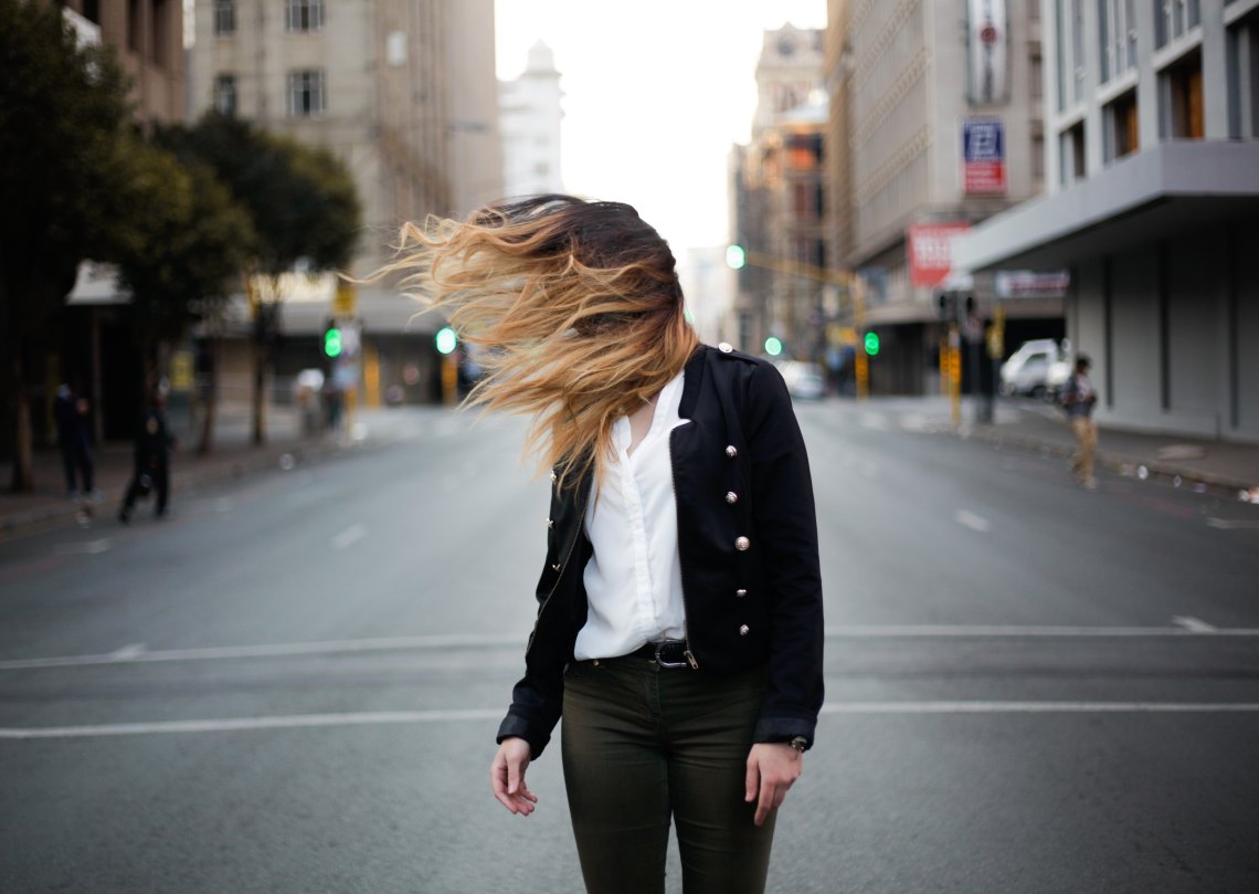 woman standing in street hair blowing in wind