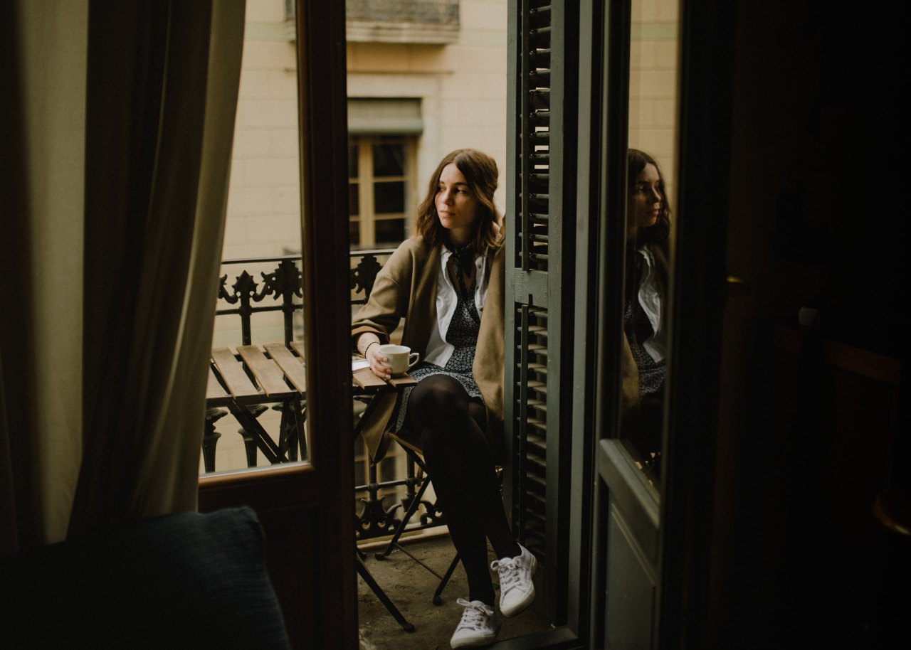 girl sitting on balcony looking contemplative